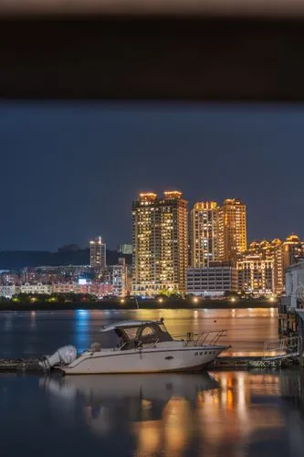 City skyline reflecting on water with a boat at evening